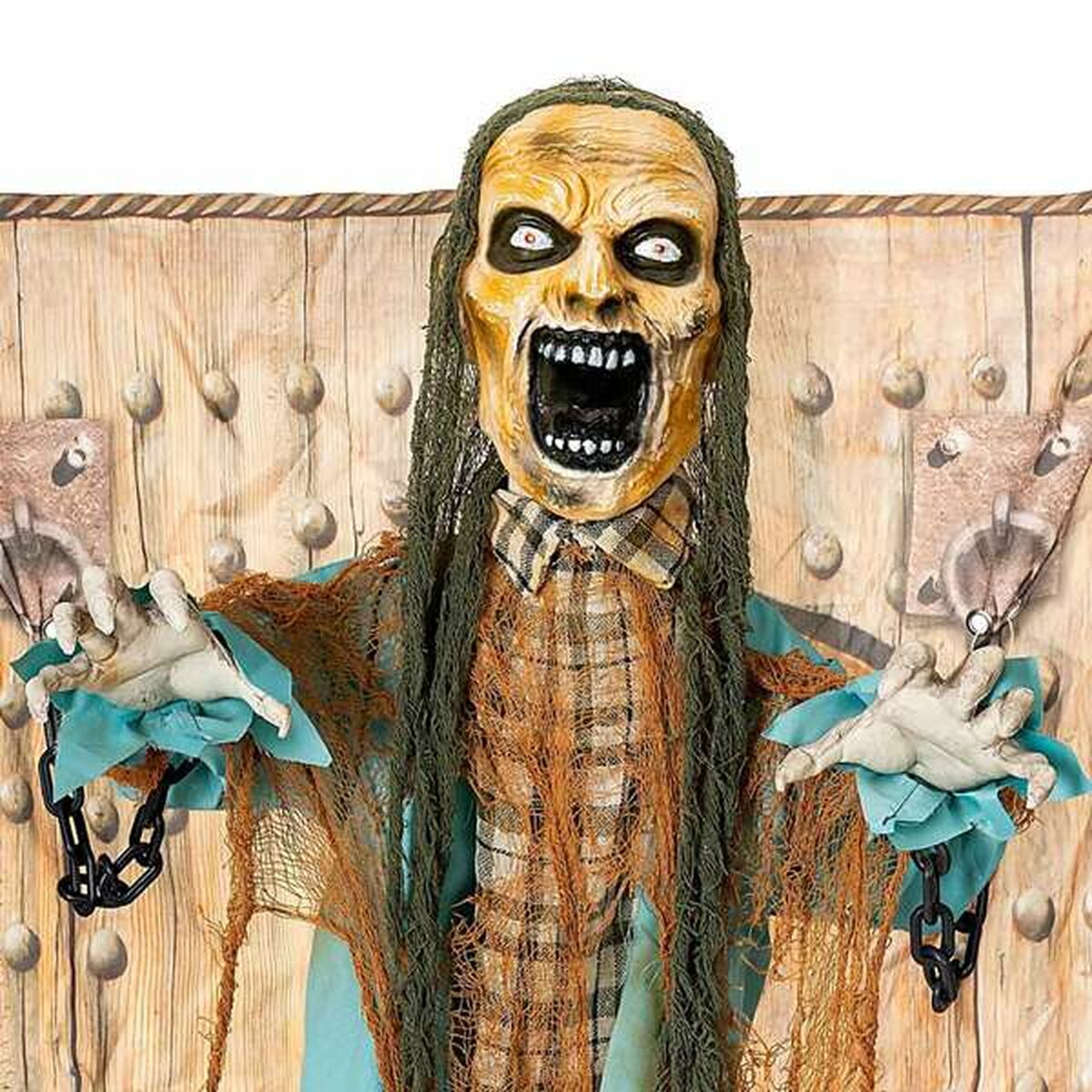 En närbild på den skrikande zombiens ansikte, med stirrande ögon, långt hår och händer som sträcker sig ut från kedjor.