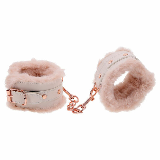 Ett par vita bojor fodrade med mjuk rosa fuskpäls och anslutna med en kort kedja med roseguldiga metallspännen.