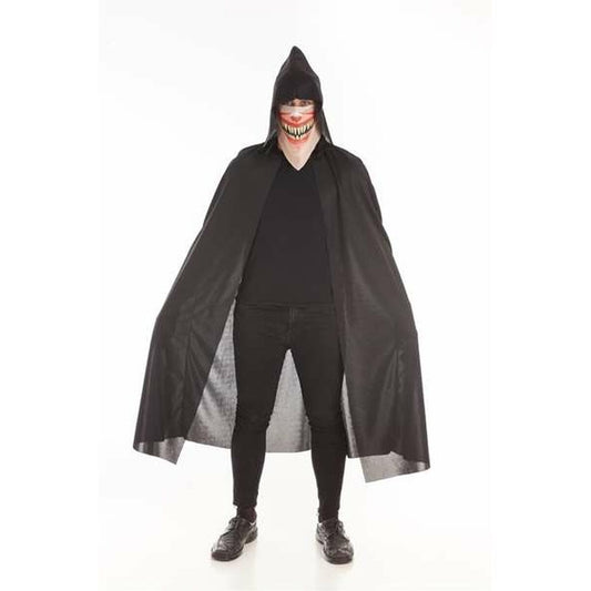 En person iklädd en svart, lång mantel med huva och en intensiv, leende ansiktsmask, stående mot en vit bakgrund.
