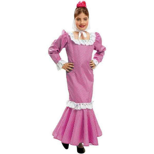 Ett barn står och poserar i en lång, figurnära rosa flamencoklänning med vita prickar, vita volanger och en vit sjal runt halsen.