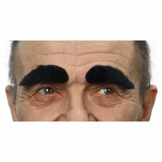 En närbild på en mans ansikte som bär stora, fluffiga svarta falska ögonbryn.