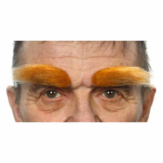Närbild på en man vars naturliga ögonbryn är ersatta med extremt tjocka, buskiga, orangea fejkögonbryn med klister.