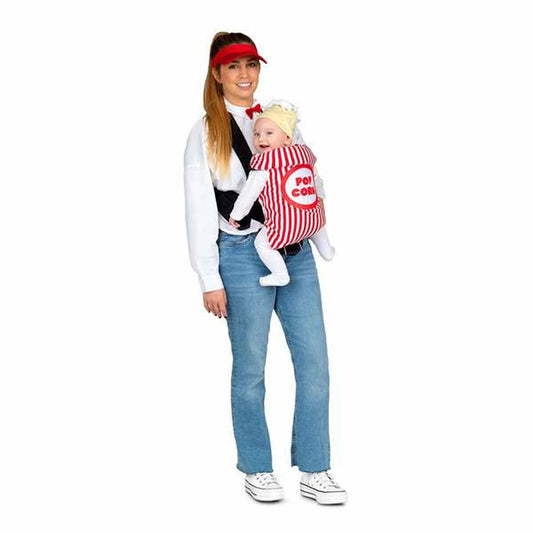En kvinna bär en bebis i en popcornpåse-dräkt, där kvinnan har en röd solskärm och en vit tröja.