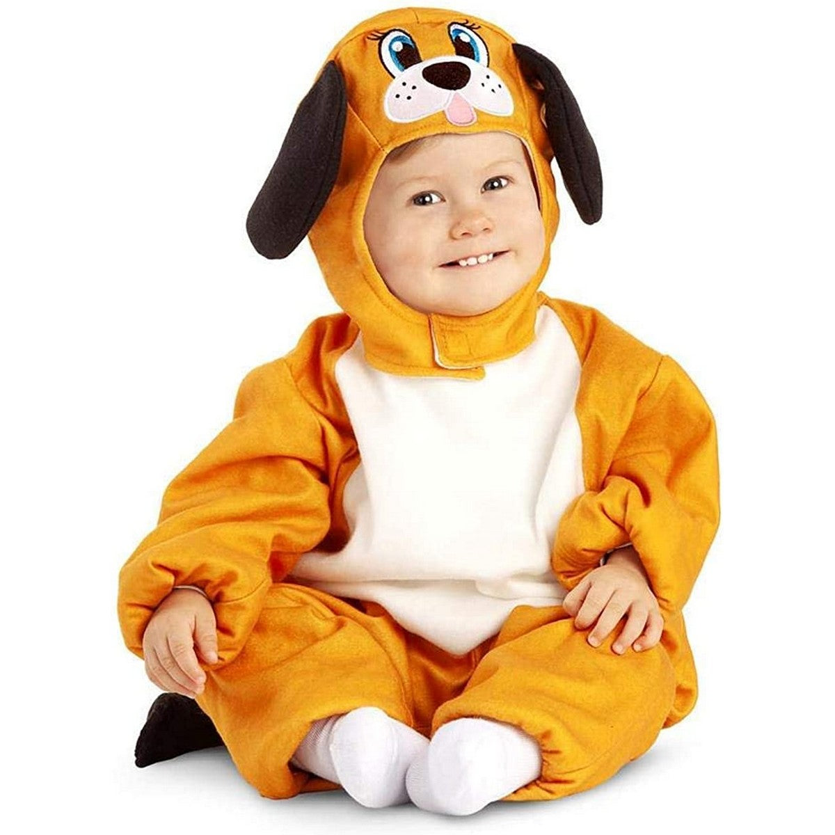 Ett leende litet barn sitter klädd i en mjuk, hel dräkt som ser ut som en orange och vit hund, komplett med huva med hundansikte och hängande öron.