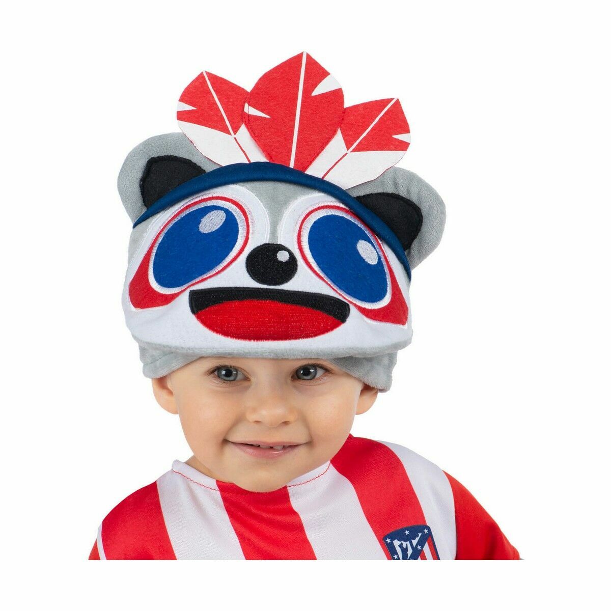 Ett litet barn ler brett medan det bär en grå och vit mjuk hatt designad som en maskot med stora blå ögon, en liten svart näsa, röd mun och tre röda och vita fjädrar som sticker upp baktill.