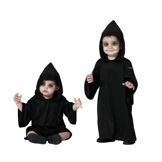 Två små barn, en sittande och en stående, klädda i svarta, långa Halloween-kåpor med spetsiga huva och fejkad sömnad runt munnen.