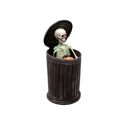 En kuslig skelettdoldis med lysande gröna revben sticker upp ur en svart soptunna med locket öppet.