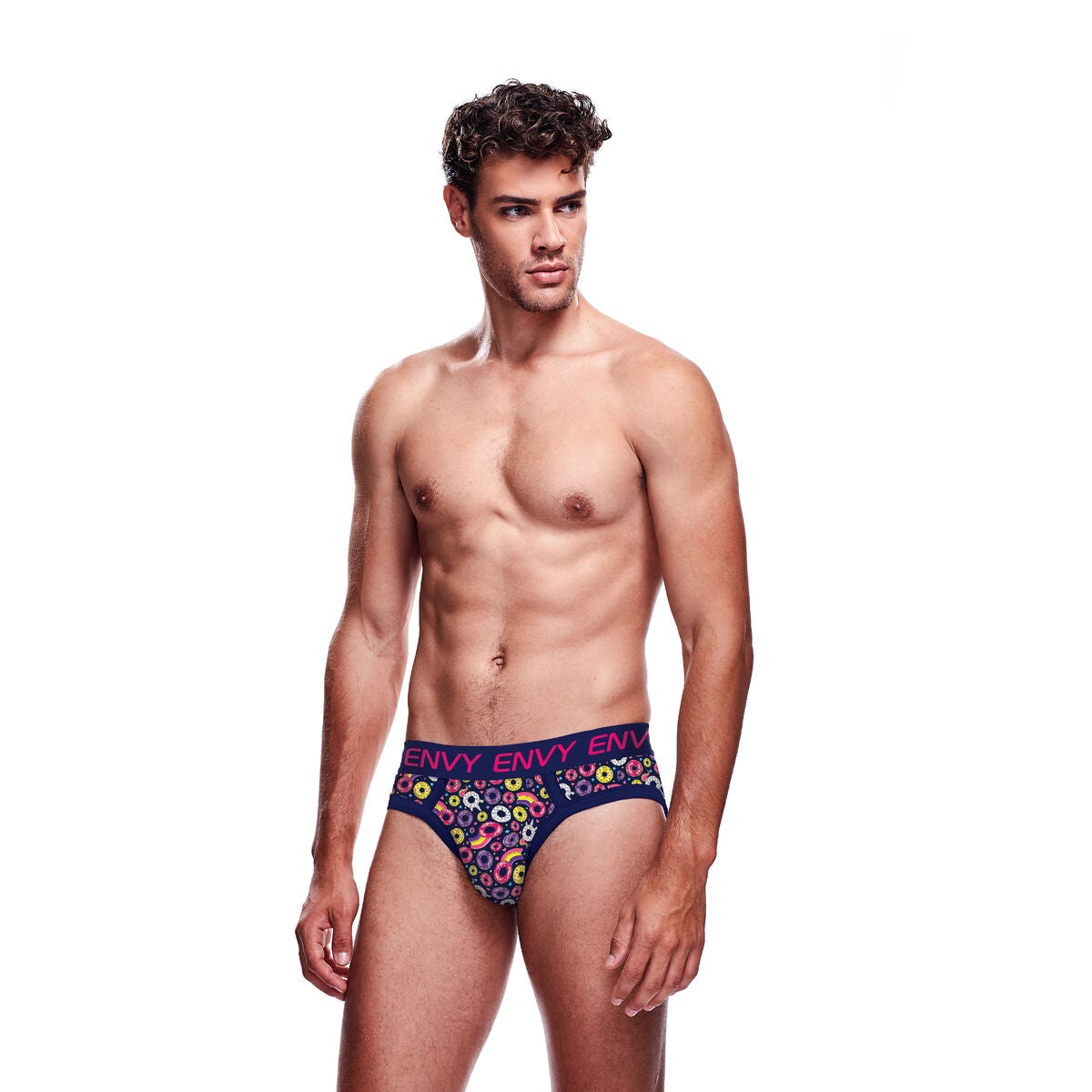 En man framifrån iklädd mörkblå briefs med ett tätt mönster av färgglada munkar och enhörningar från märket Envy.
