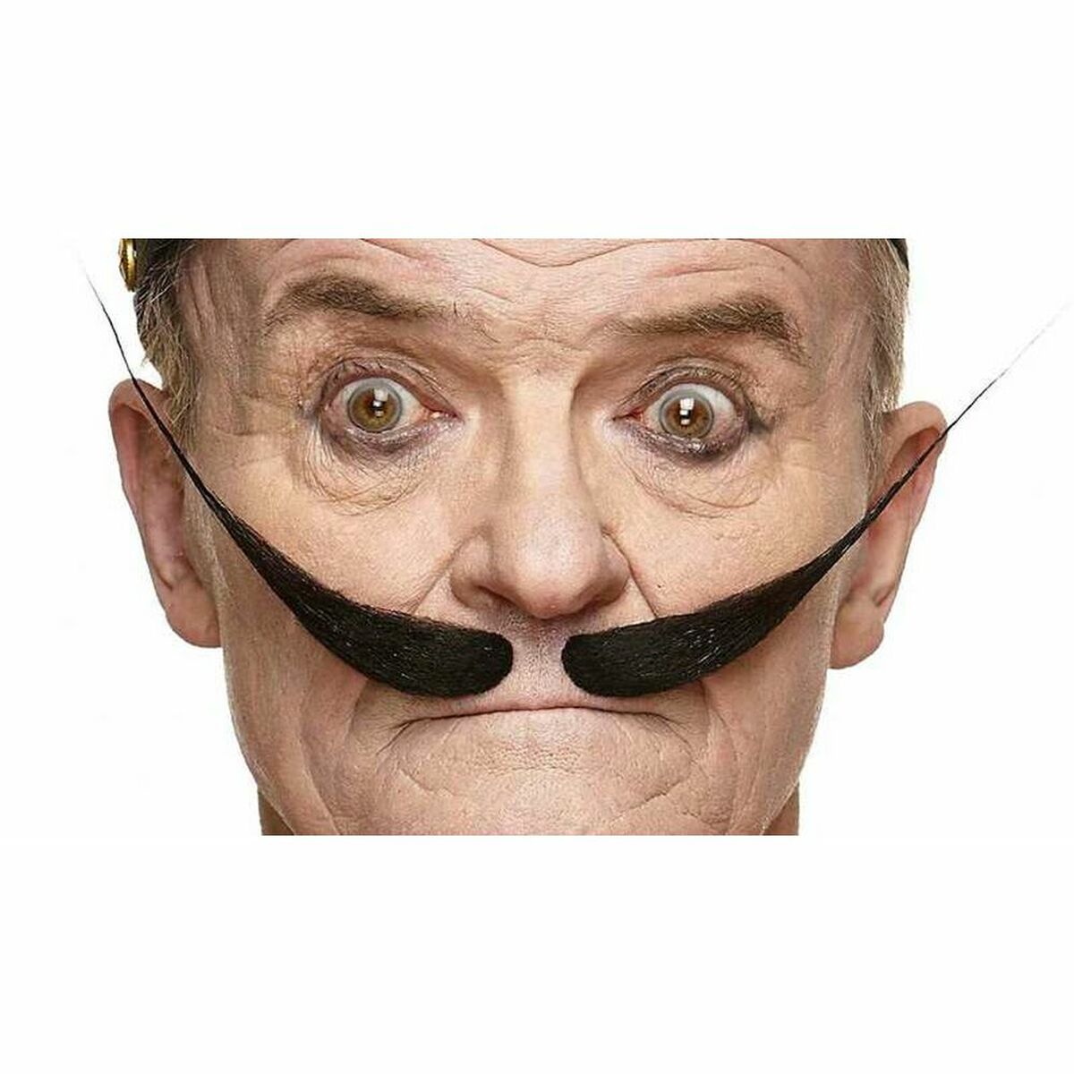 En man med en vild, uppspärrad blick bär en ikonisk, svart konstnär-lössmustasch med extremt långa, uppåtpekande ändar, fotograferad i studio.