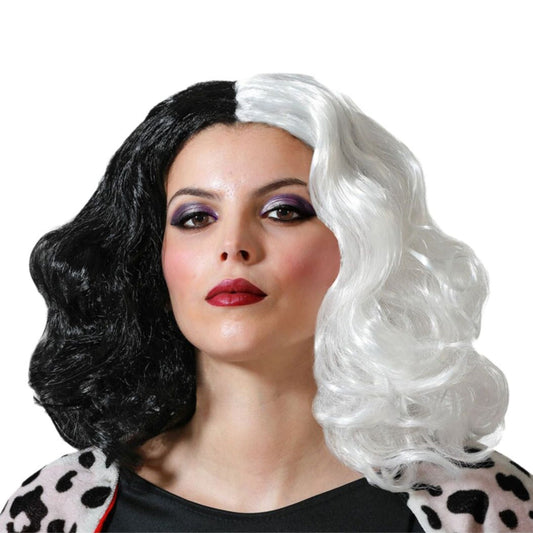 En kvinna med dramatisk makeup bär en ikonisk, axellång peruk som är delad i en svart och en vit halva med stora, eleganta lockar.