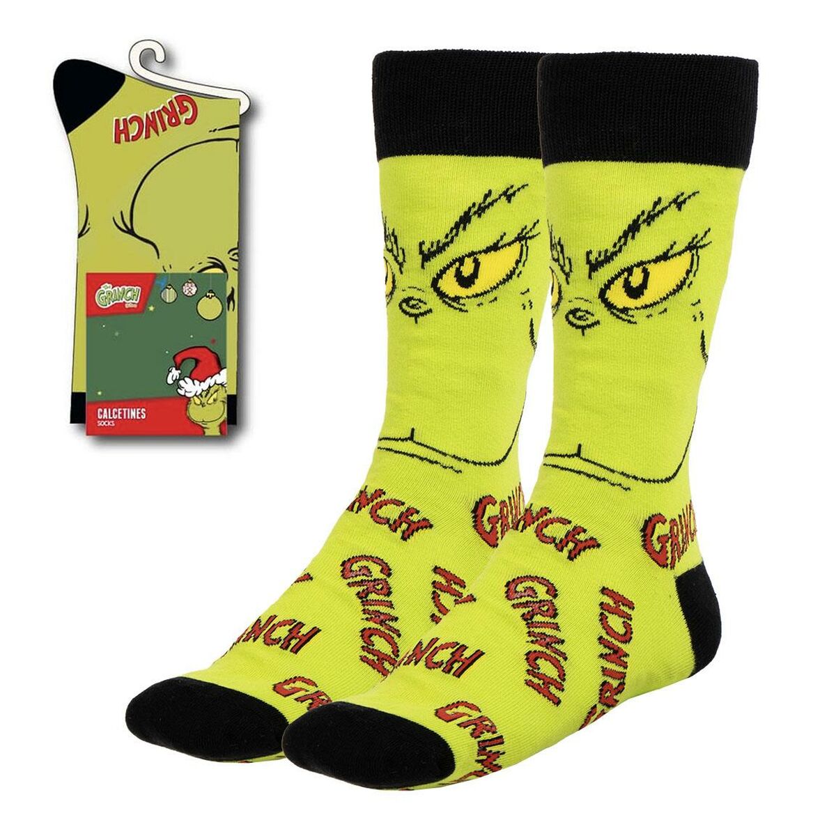 Ett par knallgröna strumpor med Grinchens sura ansikte och svarta detaljer, bredvid sin förpackning.