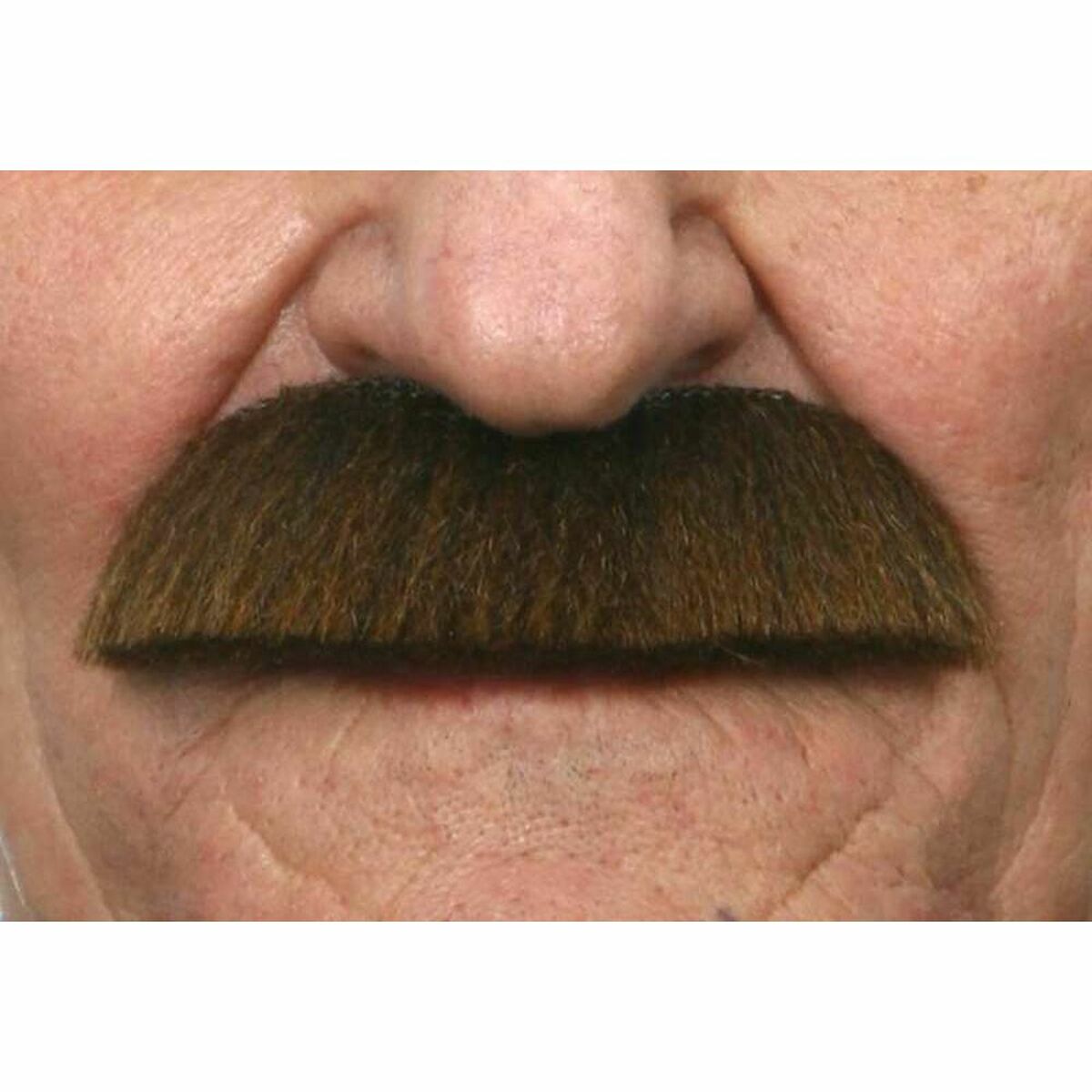 En brun, tät herrmustasch som sitter fastklistrad under en persons näsa och över överläppen.