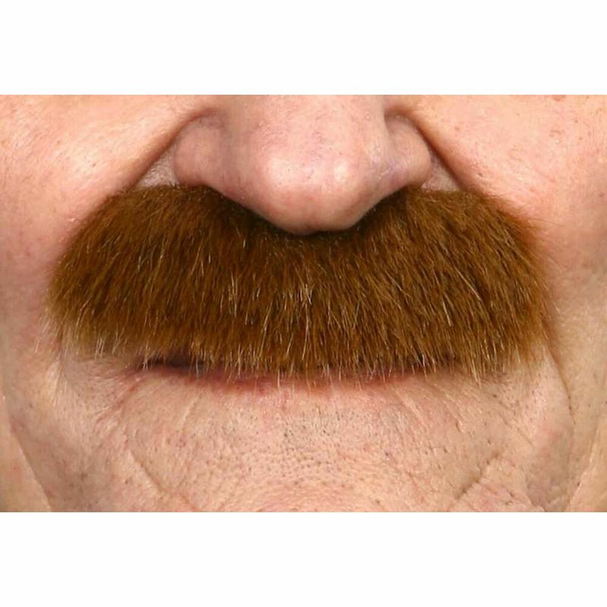 Närbild på en person som bär en stor, tjock, brun mustasch fäst precis ovanför överläppen.