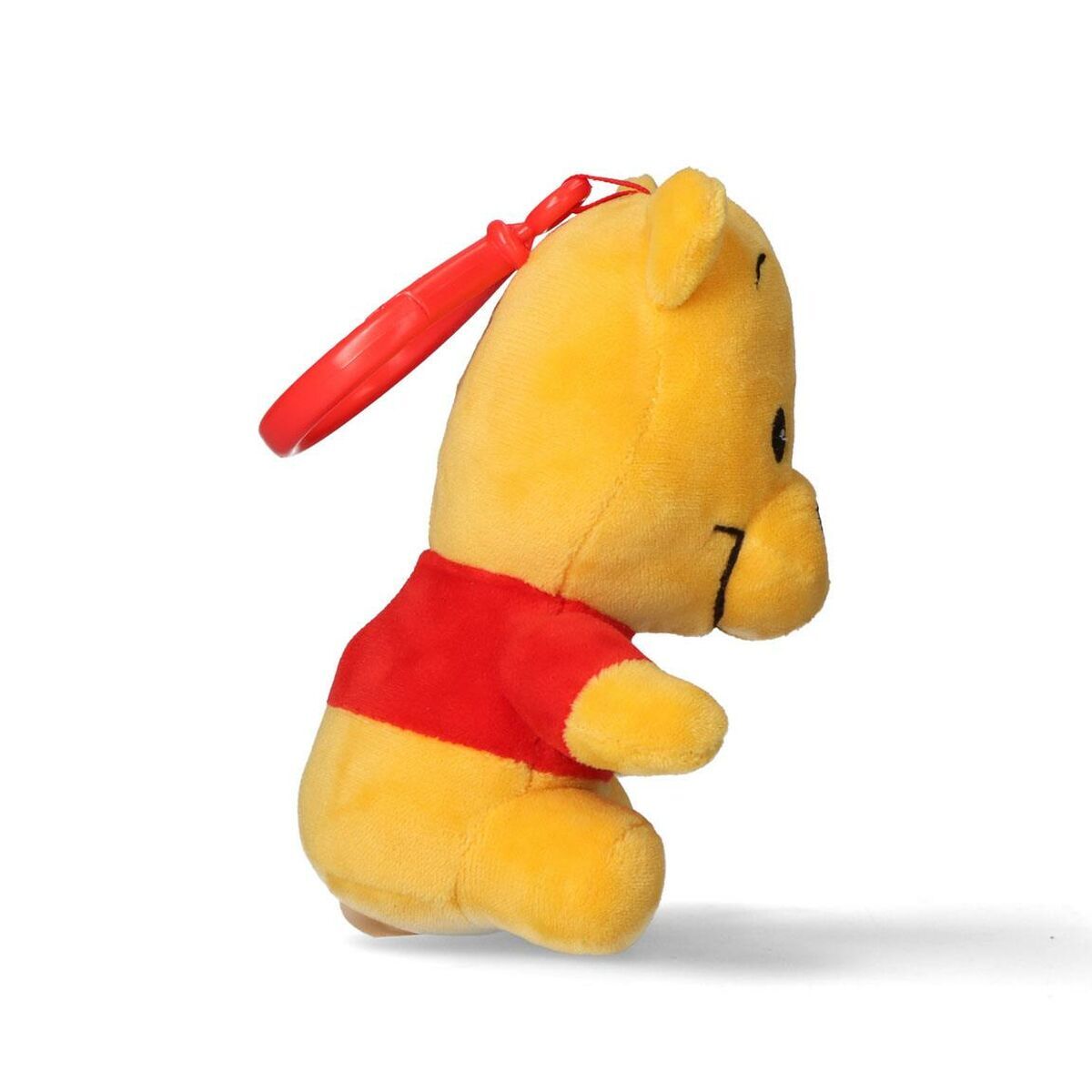 Profilbild av mjukisdjuret Nalle Puh sedd från sidan där man tydligt ser den röda fästringen och hans runda mage.