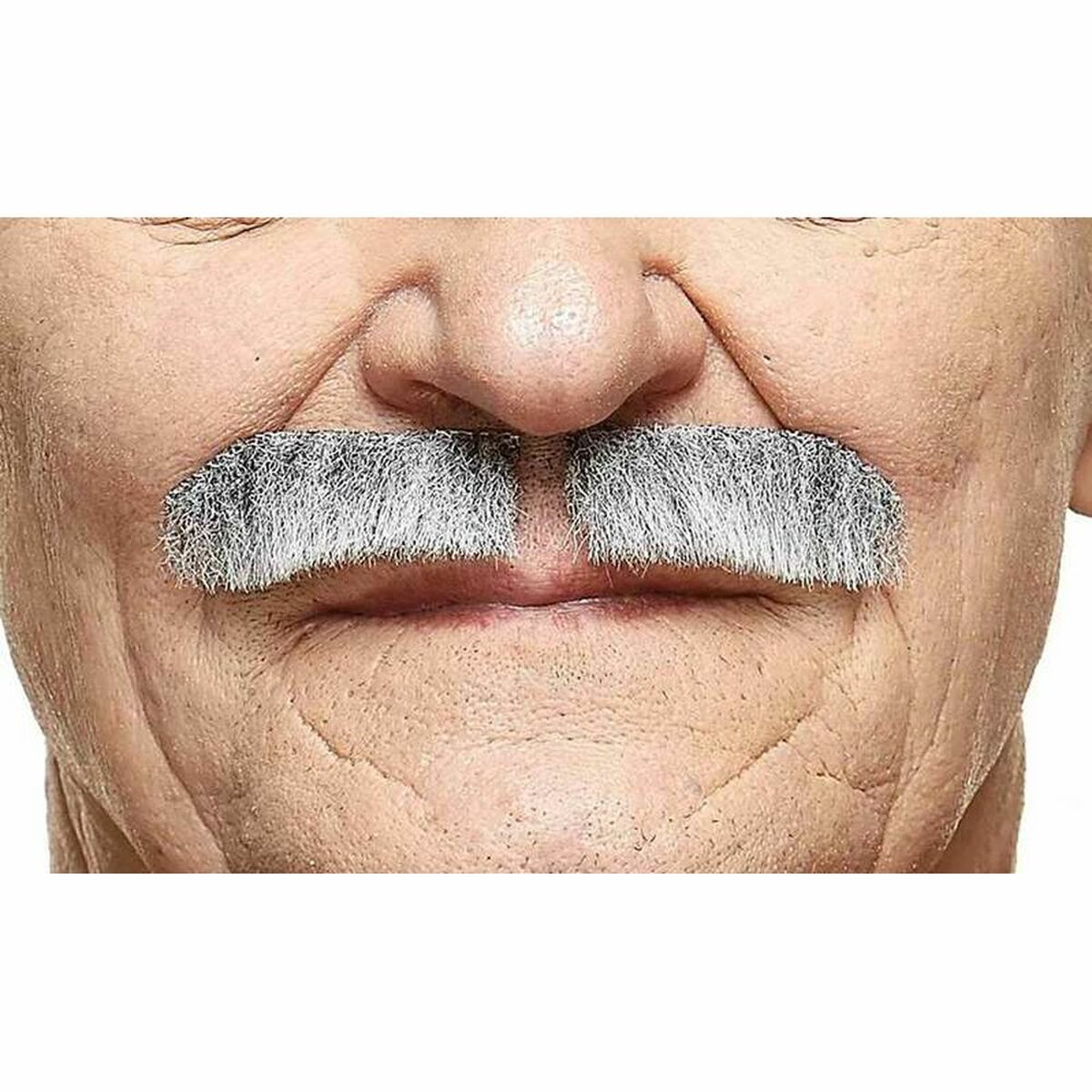 Närbild på en äldre mans ansikte som bär en realistisk, tjock, gråsprängd direktörsmustasch över munnen.